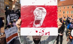 A protester holds a placard with a screaming face on the traditional Belarusian flag, symbol of the opposition, as Belarusians living in Poland and Poles demand freedom for Belarus opposition activist Raman Pratasevich in 2021