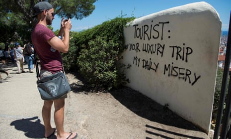 Graffiti at Park Güell in Barcelona reflects local feelings about the overwhelming number of tourists in the city.