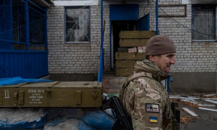 A Ukrainian soldier checks the site of a former Russian military base for mines and booby traps