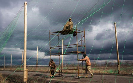 Ukrainian servicemen install anti-drone nets along a road near Sloviansk.