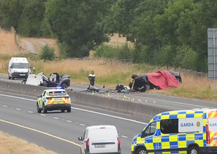 Garda vehicles by two crumpled cars on a motorway.