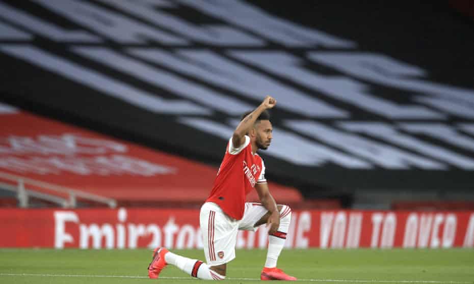 Arsenal’s Pierre-Emerick Aubameyang kneels before a Premier League game with a Black Lives Matter banner in the background at the Emirates