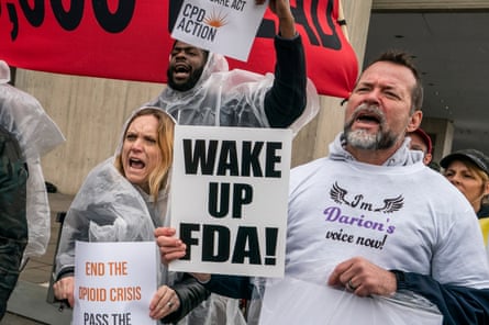 a person holds a sign that reads “wake up fda”