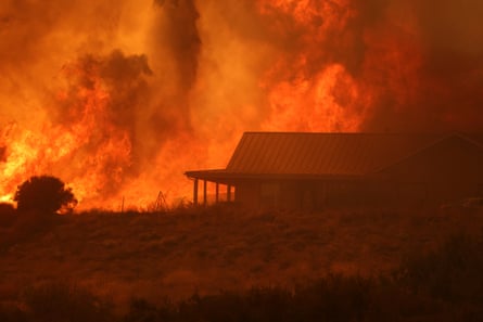 silhouette of home engulfed in flames