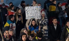 A protestor in the UK holds up a banner in support of Ukranian refugees.