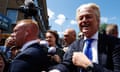 Geert Wilders shakes hands with a person as he visits a street market