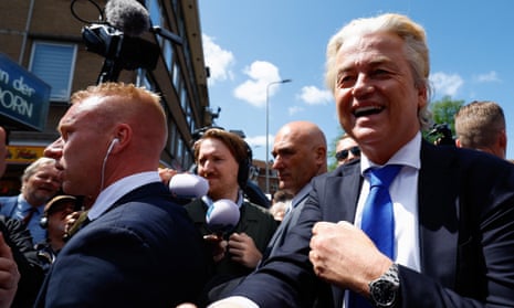 Geert Wilders shakes hands with a person as he visits a street market