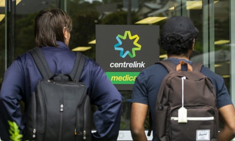 Two people in front of centrelink sign