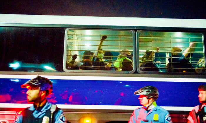 Detained demonstrators are taken to the police station by buses at the end of protest marches against racism and issues with the presidential election, in Minneapolis, Minnesota.