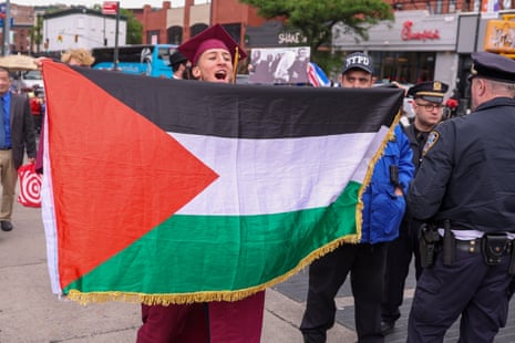 A graduate holds a Palestine flag as he joins students, graduates, faculty, and others protesting against the City University of New York and Barclay’s involvement with Israel, outside the Barclays Centre during the Brooklyn College commencement ceremony in New York, on Friday.