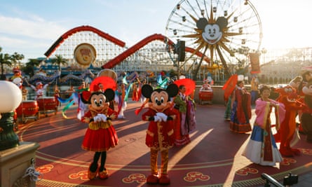 Mickey and Minnie Mouse greet visitors during lunar new year celebrations in the US. Theme parks in China have closed due to the virus outbreak.