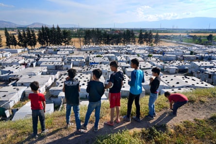 Syrian children stand on a hill above a refugee camp in the town of Bar Elias, in Lebanon’s Bekaa Valley in June 2023