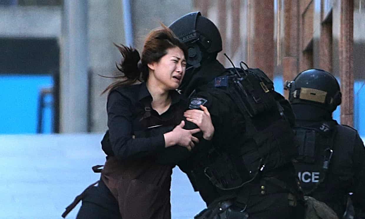 A hostage runs to armed police in Sydney.