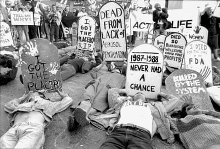 people laying down holding signs