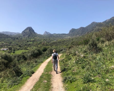 Solo hiker walking to Grazalema, Andalucía, on a sunny, blue-sky day.
