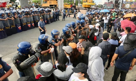 Police forces and followers of pastor Apollo Quiboloy face off outside the Kingdom of Jesus Christ compound in Davao city on 26 August