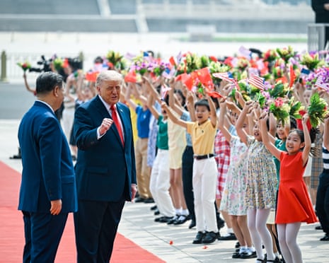 Trump stoppING to applaud children who waved bouquets of flowers and US flags during his welcoming ceremony in Beijing