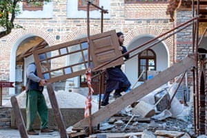 A monk helps a general worker to build and repair new parts of the monastery to house the steady influx of pilgrims