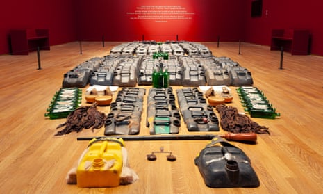An art installation comprising items including parts of jerrycans, scales and green bottles