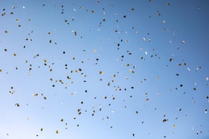 A clear, blue sky is filled with leaflets dropped by the Israeli military urging residents to leave their homes