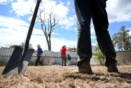 Silhouette of legs and a shovel standing in the grounds as volunteers and archeologists search