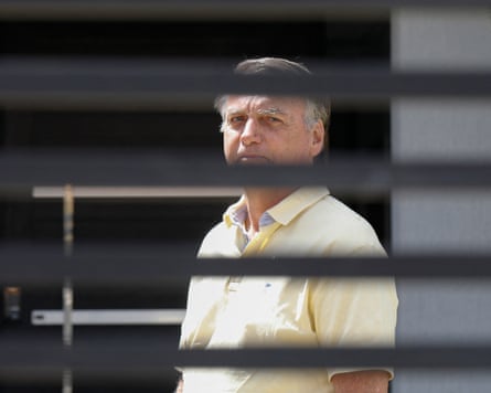 Jair Bolsonaro seen through gates that partially obscure the view