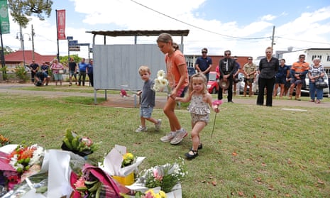 Children lay flowers at Chinchilla police station in Queensland in memory of the two officers killed in the Wieambilla shooting.