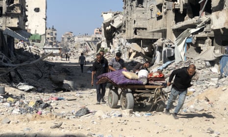People in Beit Lahia, northern Gaza, at the weekend are pictured pulling a cart laden with belongings.