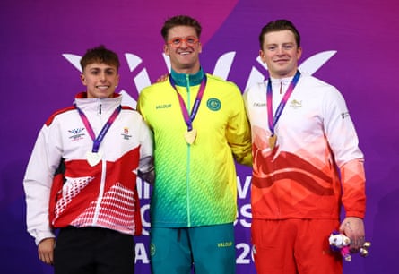 Sam Williamson celebrates connected nan podium aft winning nan men’s 100m breaststroke last pinch Jersey’s Filip Nowicki and England’s Adam Ramsay-Peaty.