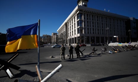 Ukrainian soldiers stand guard at a military checkpoint in Kyiv