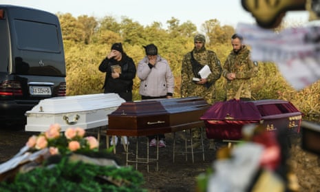 Relatives and friends attend the funeral for victims of a Russian missile attack on the village cafe in the village of Hroza, near Kharkiv, Ukraine.