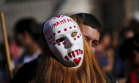 A woman wearing a mask with the slogan ‘Not one less’ embraces a fellow demonstrator during a protest against femicide outside Congress in the Argentinian capital Buenos Aires