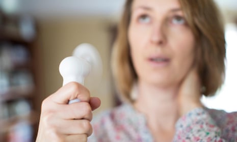 Woman experiencing hot flush from menopause using electric fan