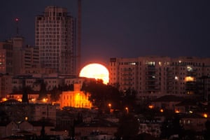 An unusual shot of the moon appearing wedged between buildings in Jerusalem, Israel