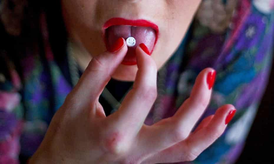 A woman takes an ecstasy tablet.