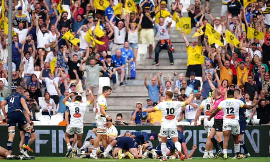 La Rochelle’s Pierre Bourgarit (hidden) scores his side’s second try of the game as fans celebrate.