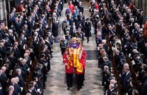 King Charles III, the Queen Consort, the Princess Royal, Vice Admiral Sir Tim Laurence, the Duke of York, the Earl of Wessex, the Countess of Wessex, the Prince of Wales, the Princess of Wales, Prince George, Princess Charlotte, the Duke of Sussex, the Duchess of Sussex, Peter Phillips and the Earl of Snowdon follow behind the coffin of Queen Elizabeth II, draped in the Royal Standard with the Imperial State Crown and the Sovereign’s orb and sceptre, as it is carried out of Westminster Abbey