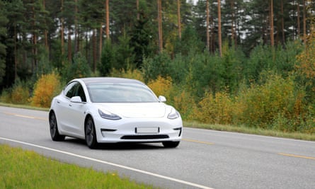 a white Tesla model 3 on a rural road
