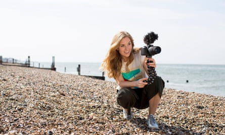 Maddie Moate on a beach with a video camera