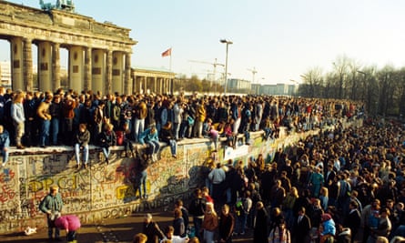 Berliners sit on Berlin Wall