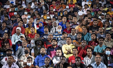 At a fan zone in a cricket stadium on the edge of Doha, migrant workers watch the first match of the 2022 World Cup – Qatar v Ecuador.