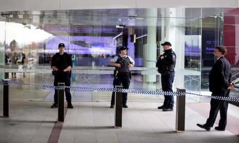 Police stand guard at the entrance of a terminal at Canberra airport after a a gun was fired inside on Sunday.