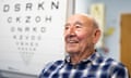 Cecil Farley sitting next to an eye test chart