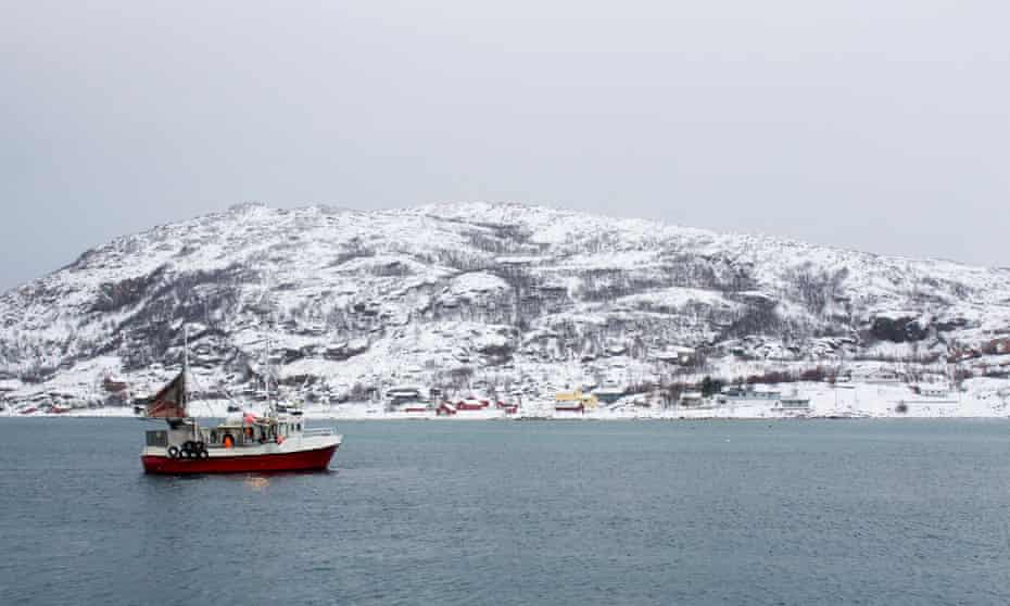 A fishing boat at sea with a snowy hill in the background