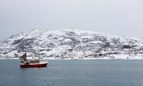A fishing boat at sea with a snowy hill in the background