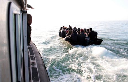 People on an open boat are approached by a larger vessel