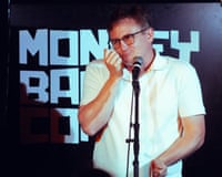 Chris Cantrill grimaces while standing at a microphone on stage