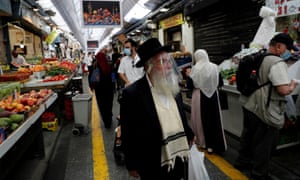 People wear face masks as they shop in a main market in Jerusalem