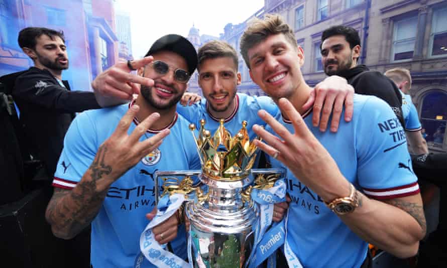 Kyle Walker, Ruben Días and John Stones celebrate with the Premier League trophy – the club’s fourth title in five seasons.