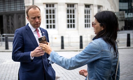 Health secretary Matt Hancock looks at the phone of his aide Gina Coladangelo as they leave the BBC in central London on 6 June, 2021.